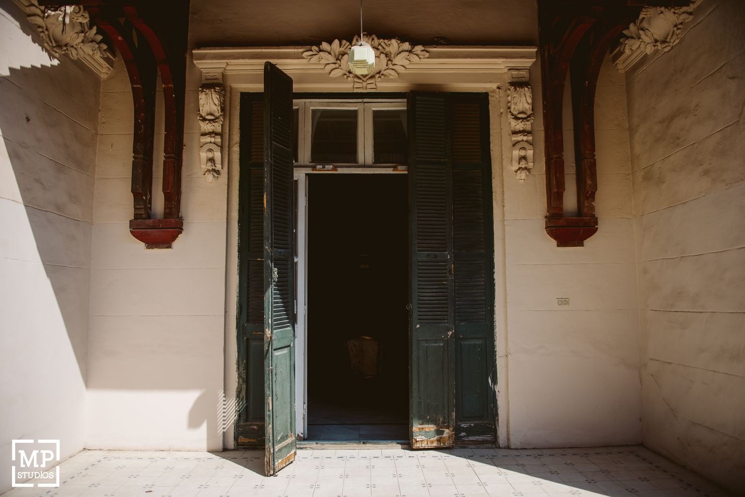 Architectural detail of grand entrance with dark wooden double doors and decorative columns.