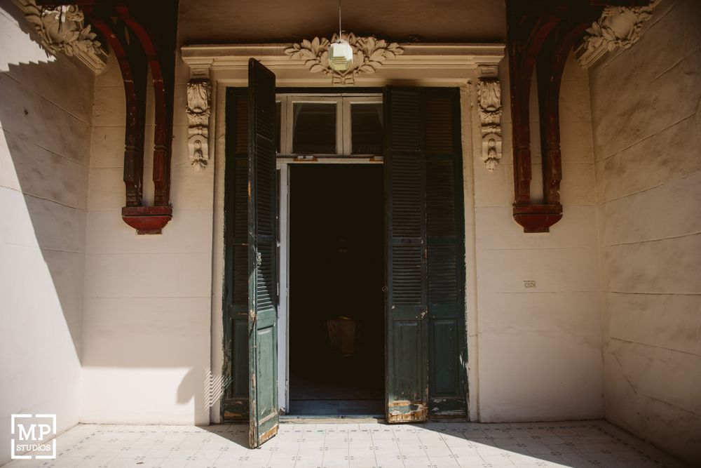 Architectural detail of grand entrance with dark wooden double doors and decorative columns.