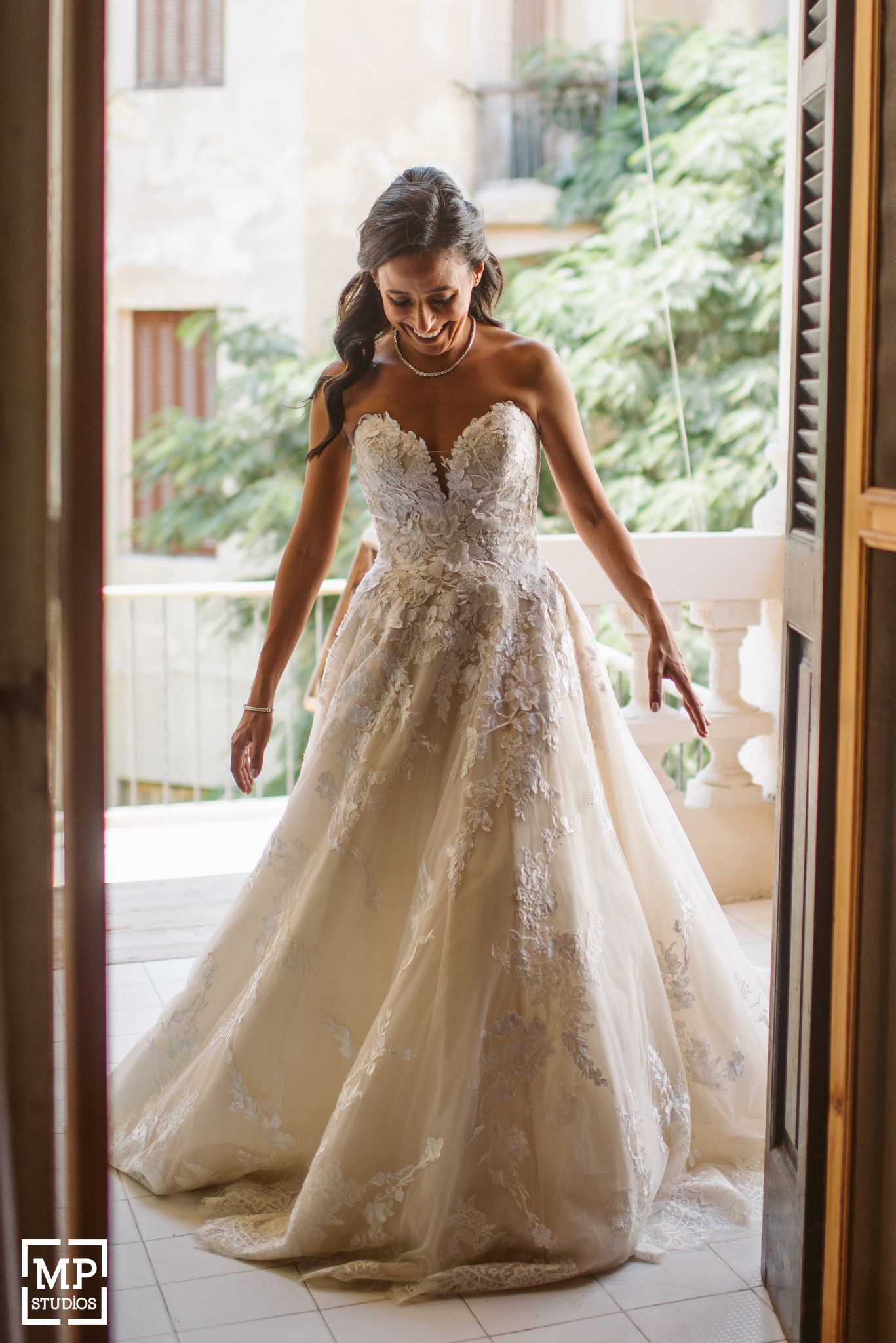 Stunning bridal gown with intricate lace details photographed in natural window light.