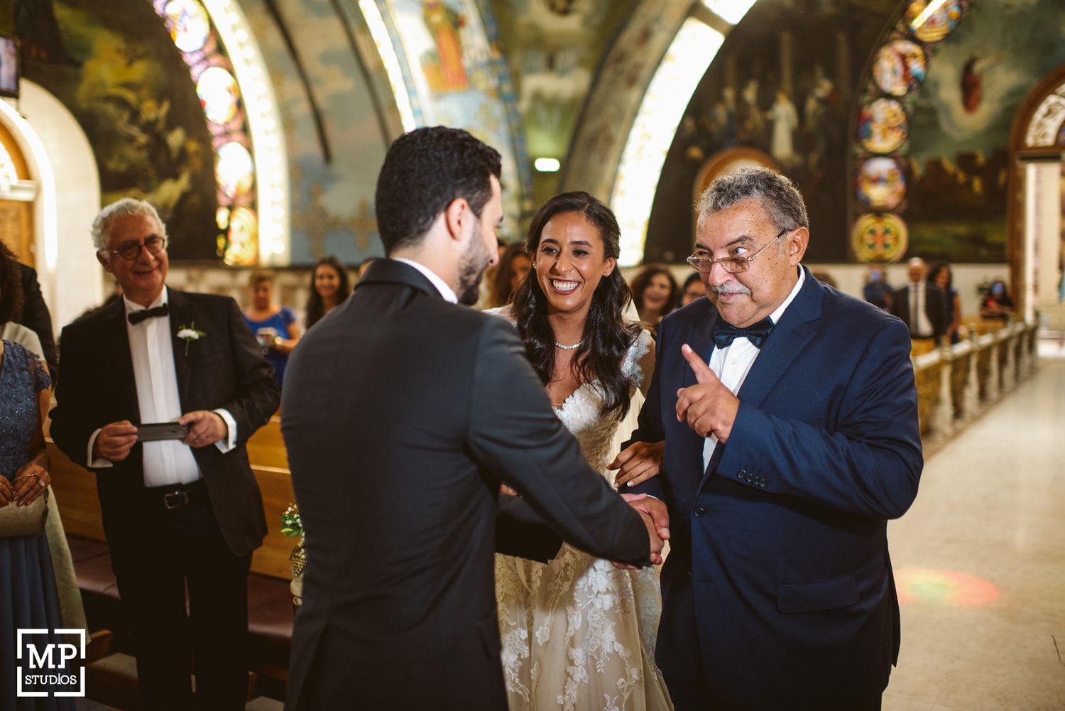 Emotional moment during church wedding ceremony with ornate backdrop.