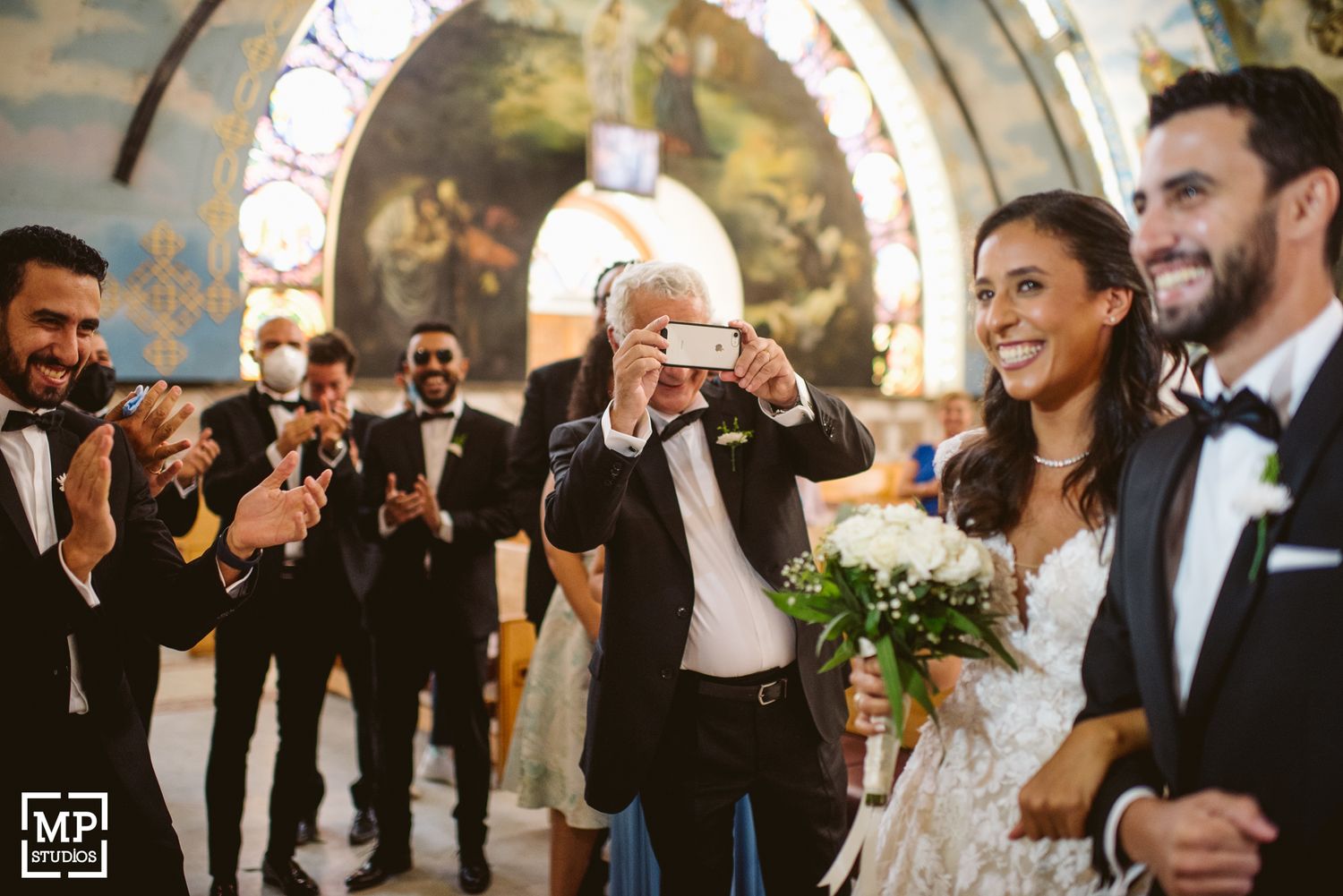 Wedding party celebrating joyfully in church after ceremony.