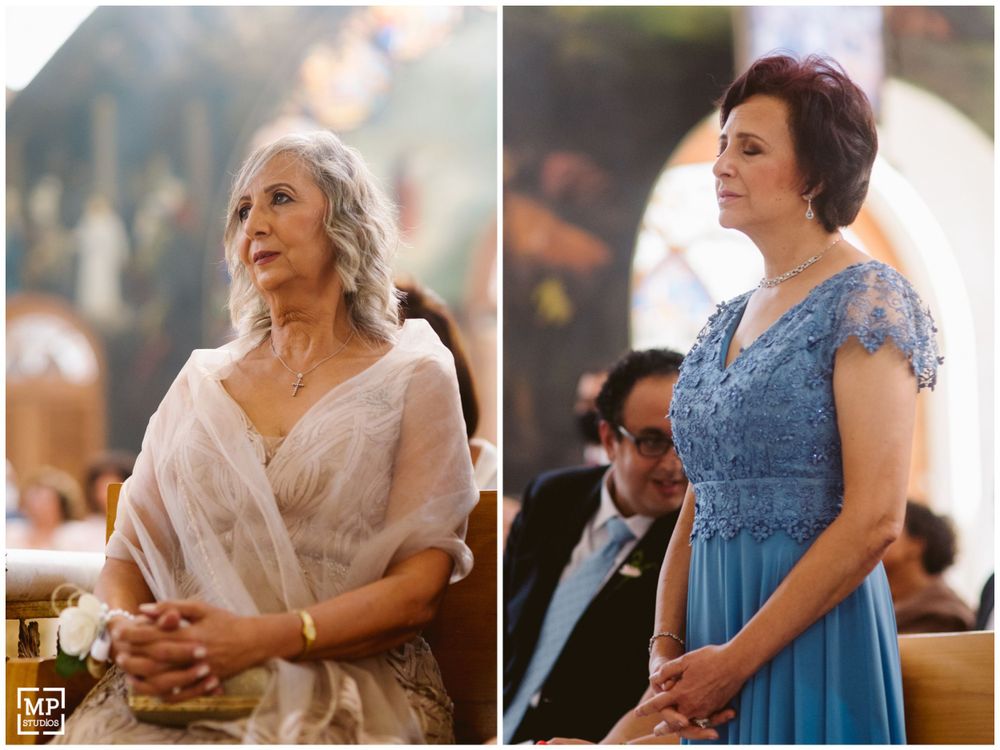 Two guests in formal attire during an elegant church wedding ceremony.