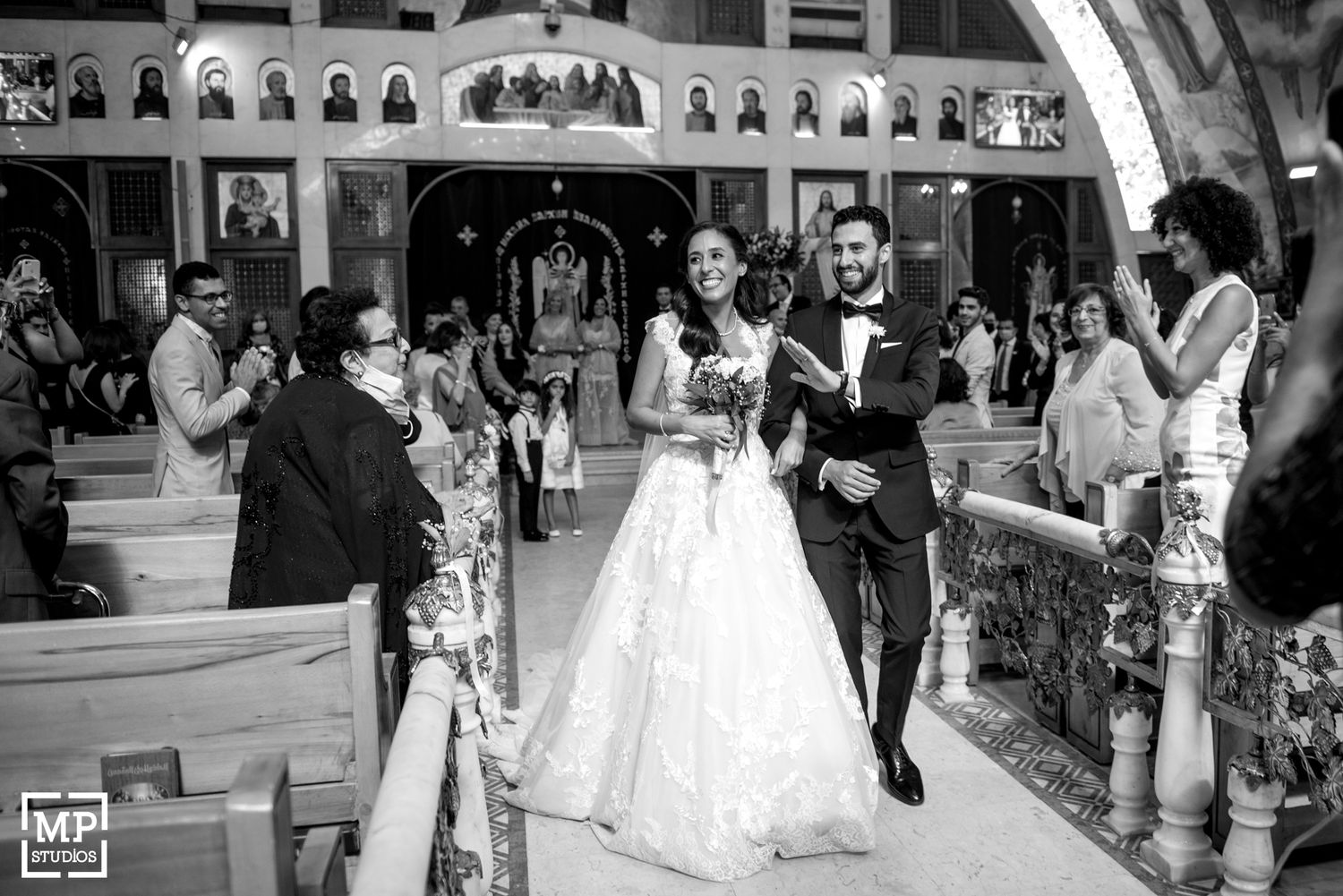 Wedding celebration in a church with guests capturing photos of the joyful moment.