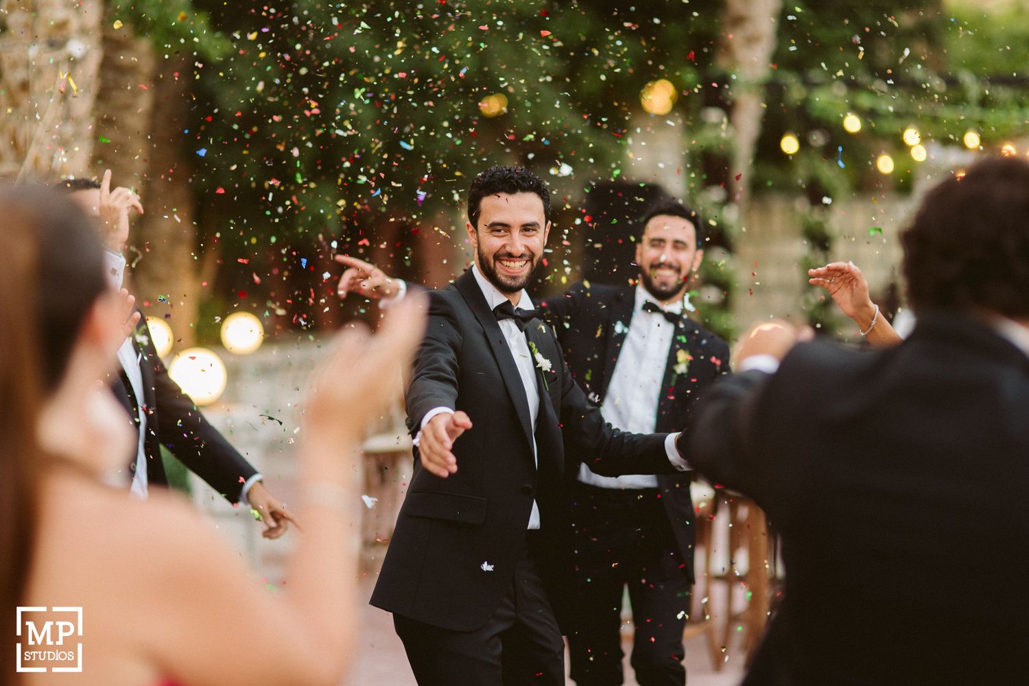 Wedding celebration with confetti being thrown during outdoor reception.