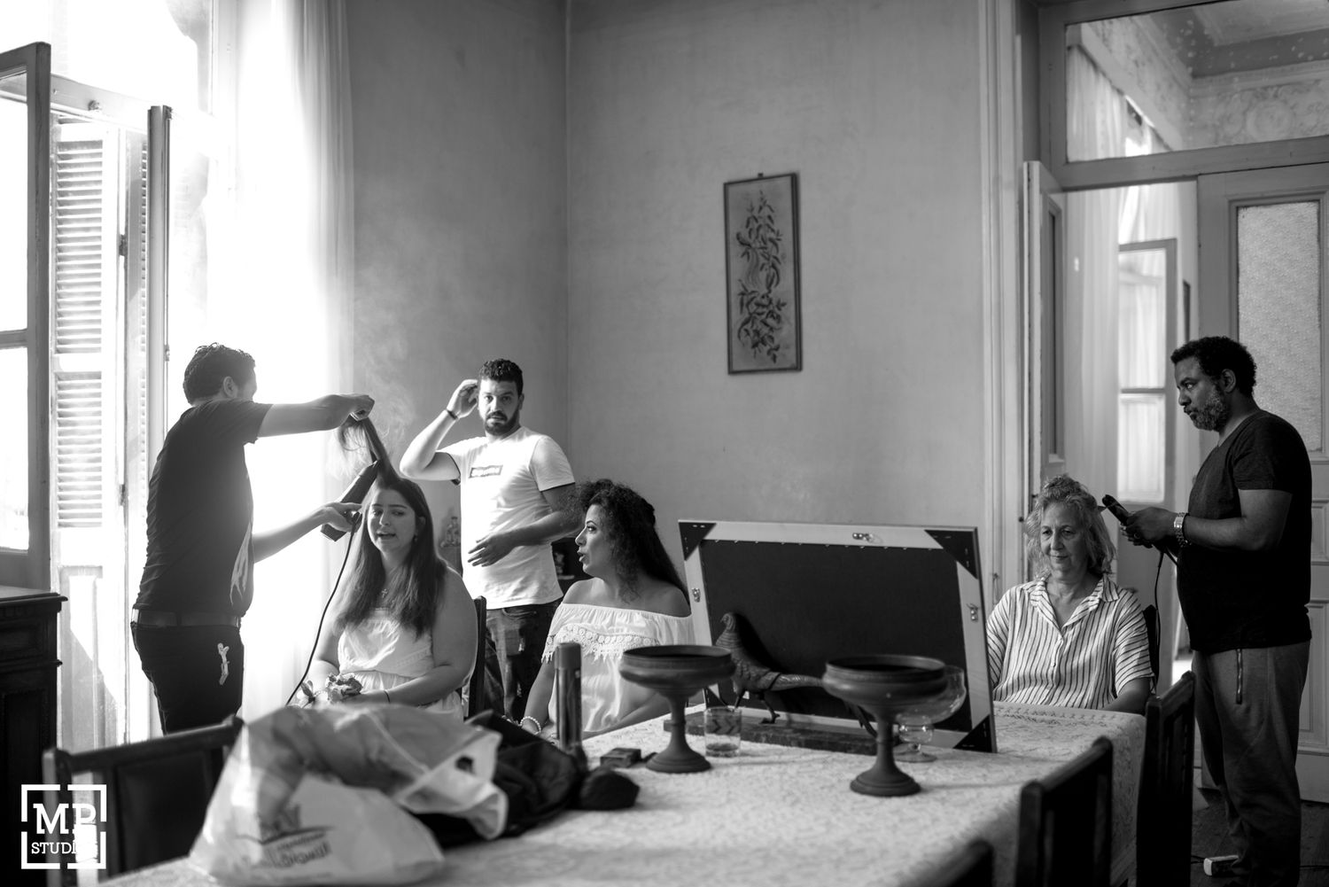 Wedding morning preparations with people getting ready in a bright room.