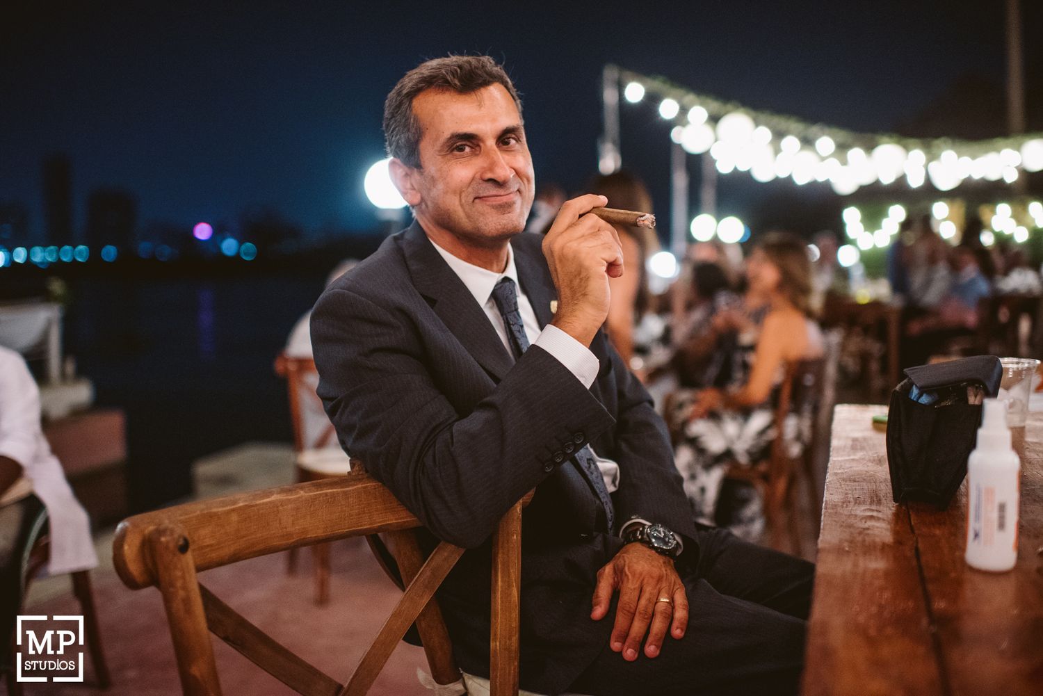 Guest enjoying a quiet moment at an evening outdoor wedding reception.