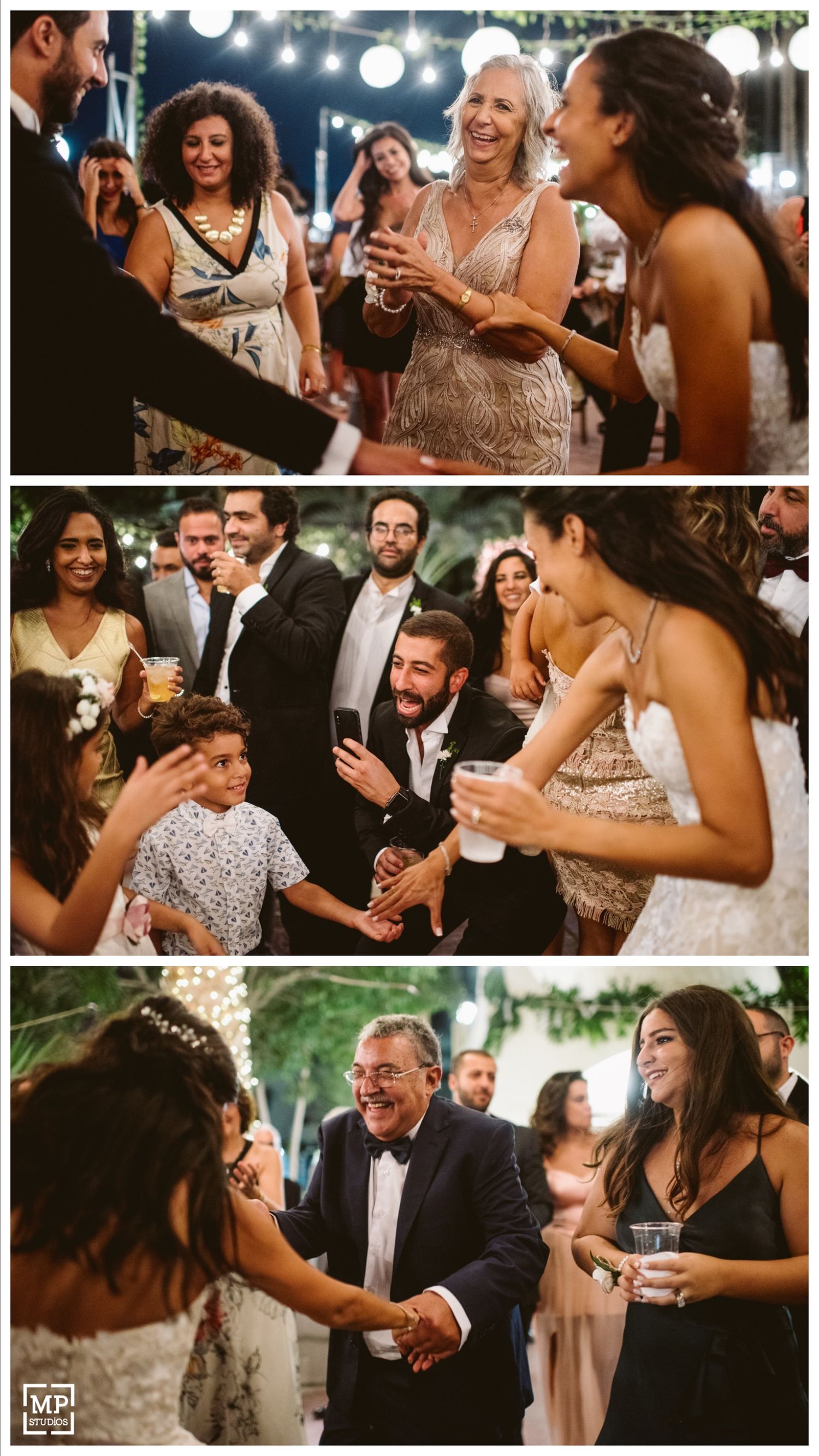Joyful celebration at a wedding reception with guests dancing and laughing under string lights.