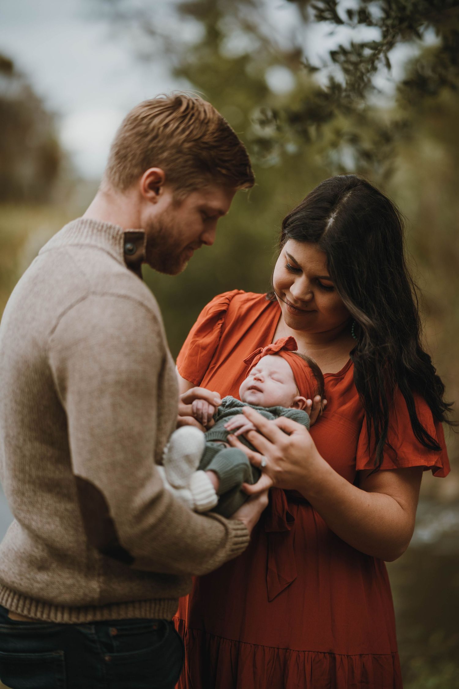 Cozy outdoor family portrait with baby in autumn setting.