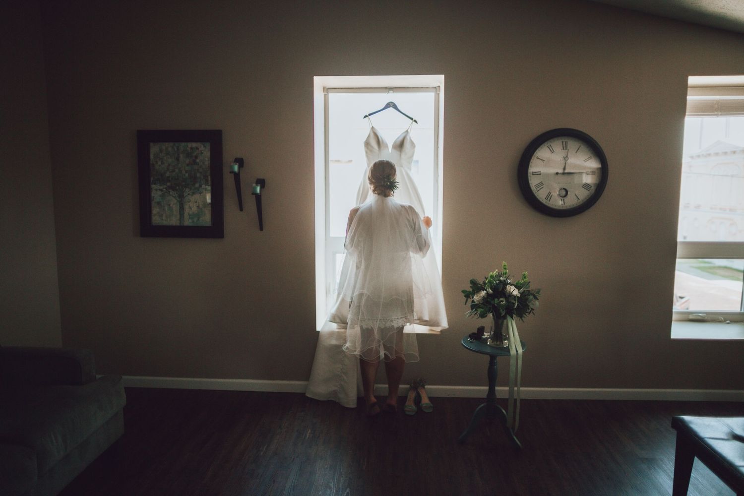 A sunlit room with a white dress hanging in the window and interior decor visible.
