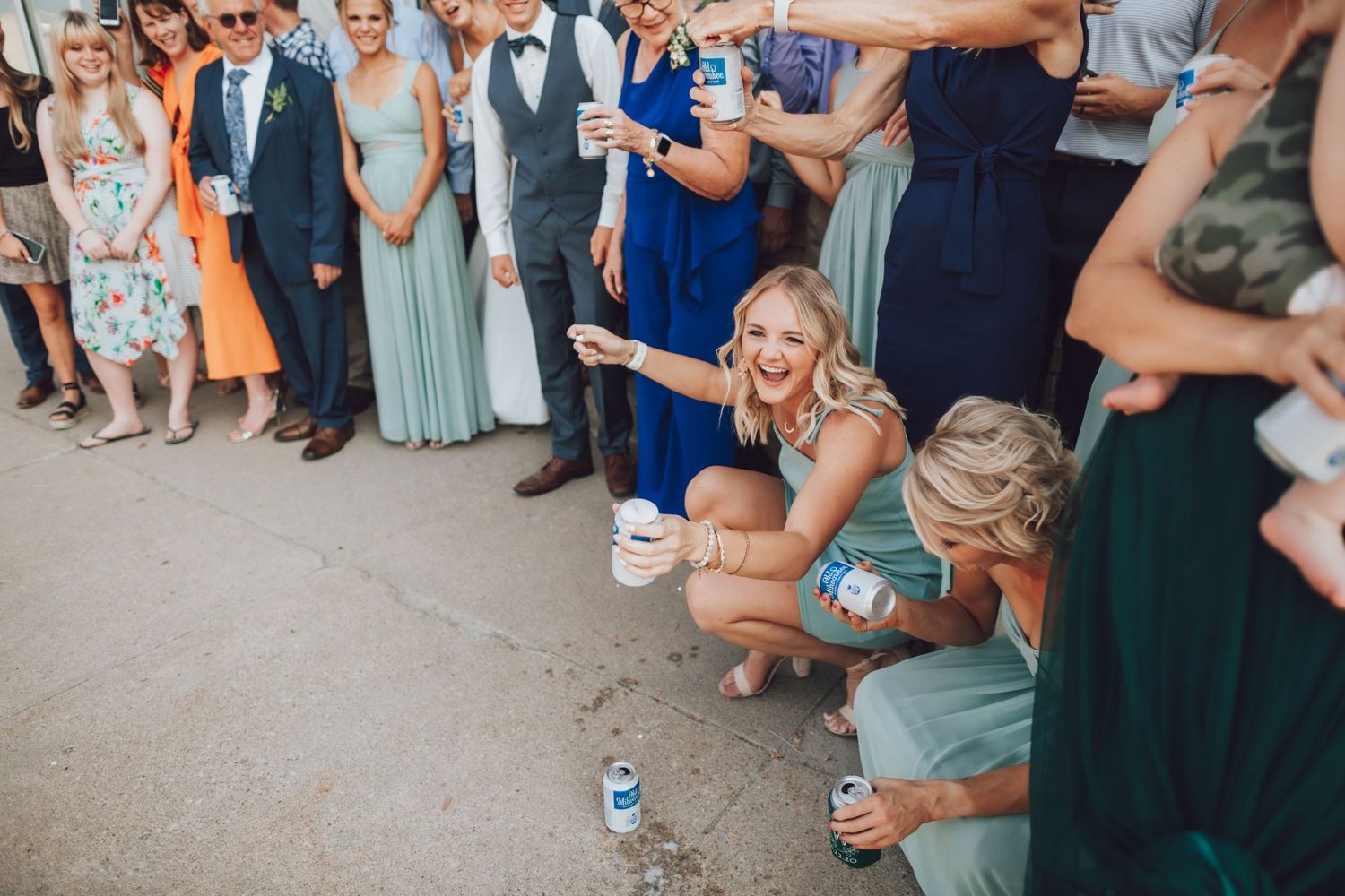 Wedding guests gather for casual group photo in mix of formal attire.