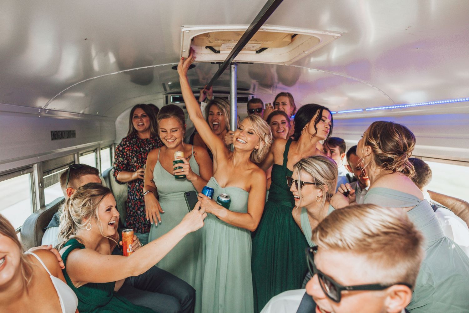 Wedding party celebrates and dances together in a party bus or limo.