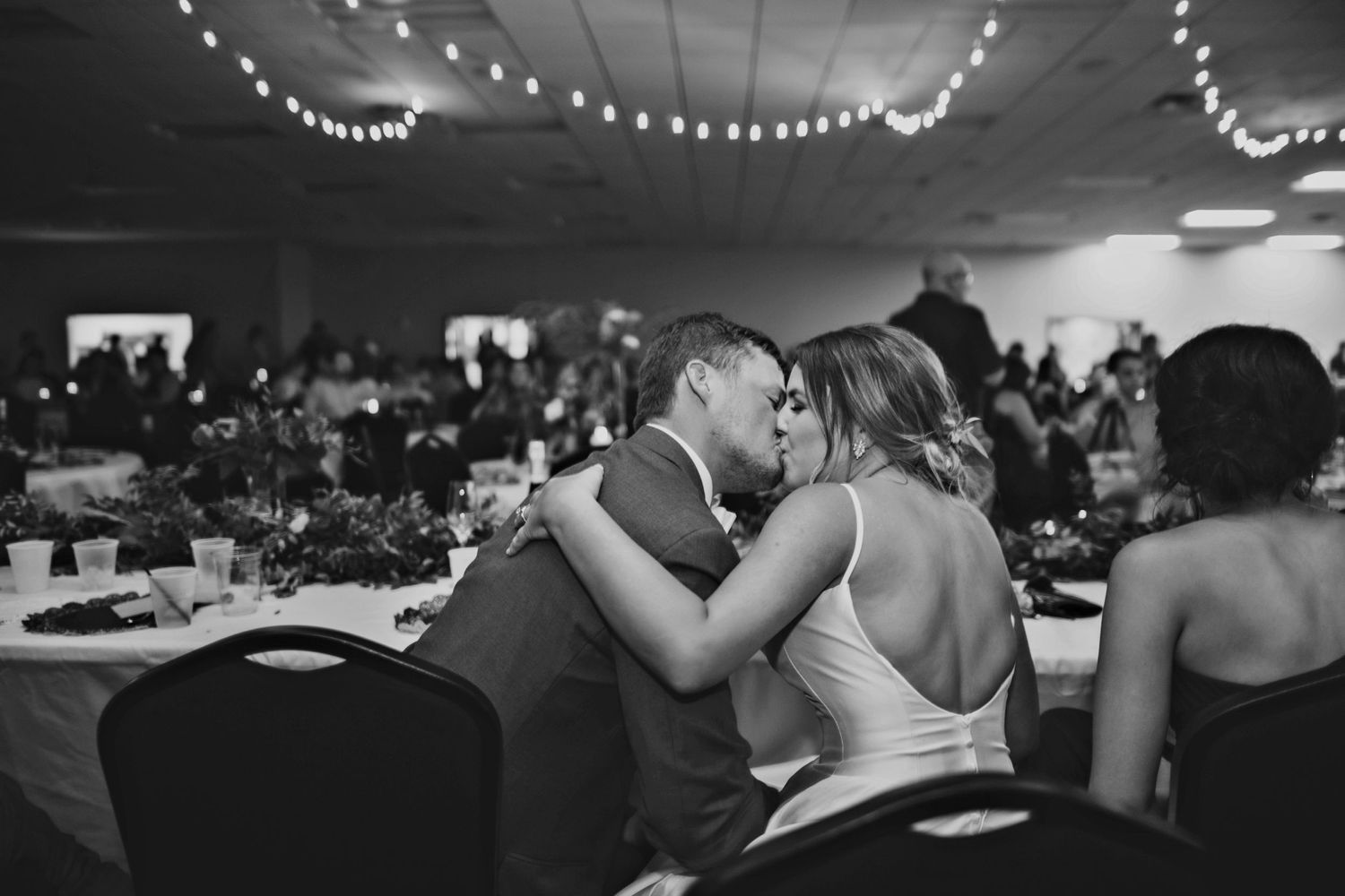 Wedding reception dance floor filled with guests celebrating under dim lighting.