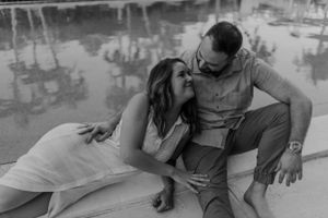 Couple sharing an intimate black and white moment by a reflective pool.