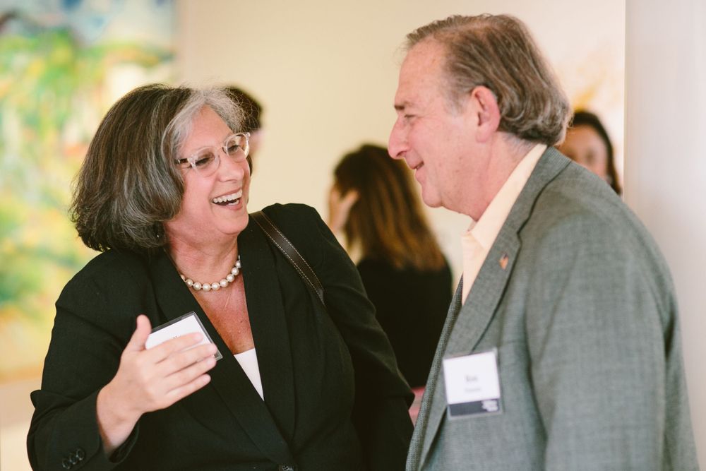 Two guests engaged in animated conversation at a professional event.