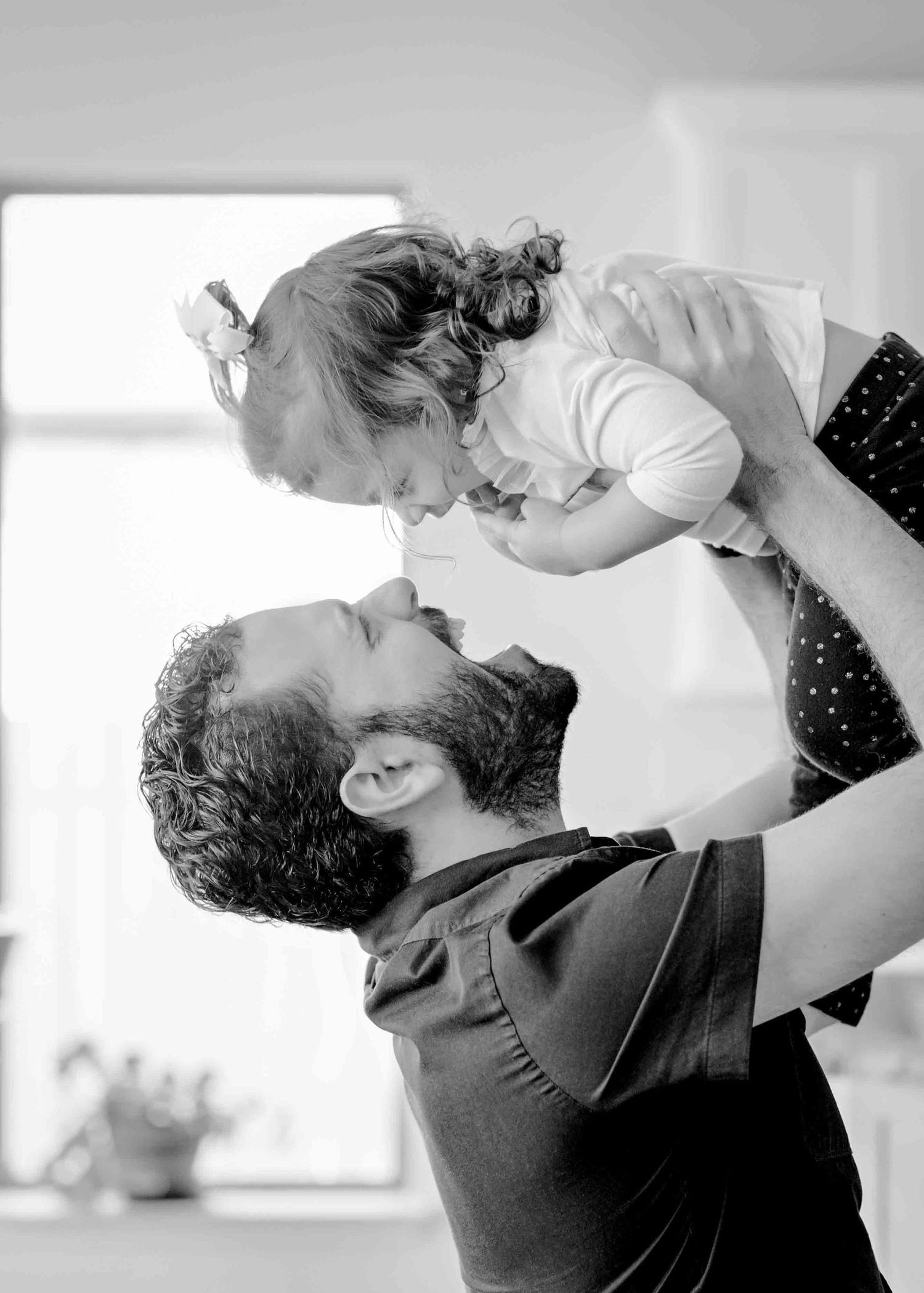 Black and white photo capturing a joyful moment between parent and child.