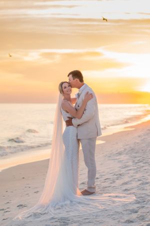 groom kissing bride at sunset on their wedding day on Panama City Beach Florida HCbeachphotogaphy