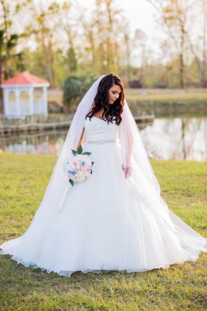 Bride posing in front of lake on her wedding day in Panama City Florida