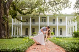 Groom dipping bride in front of mansion in Panama City Florida
