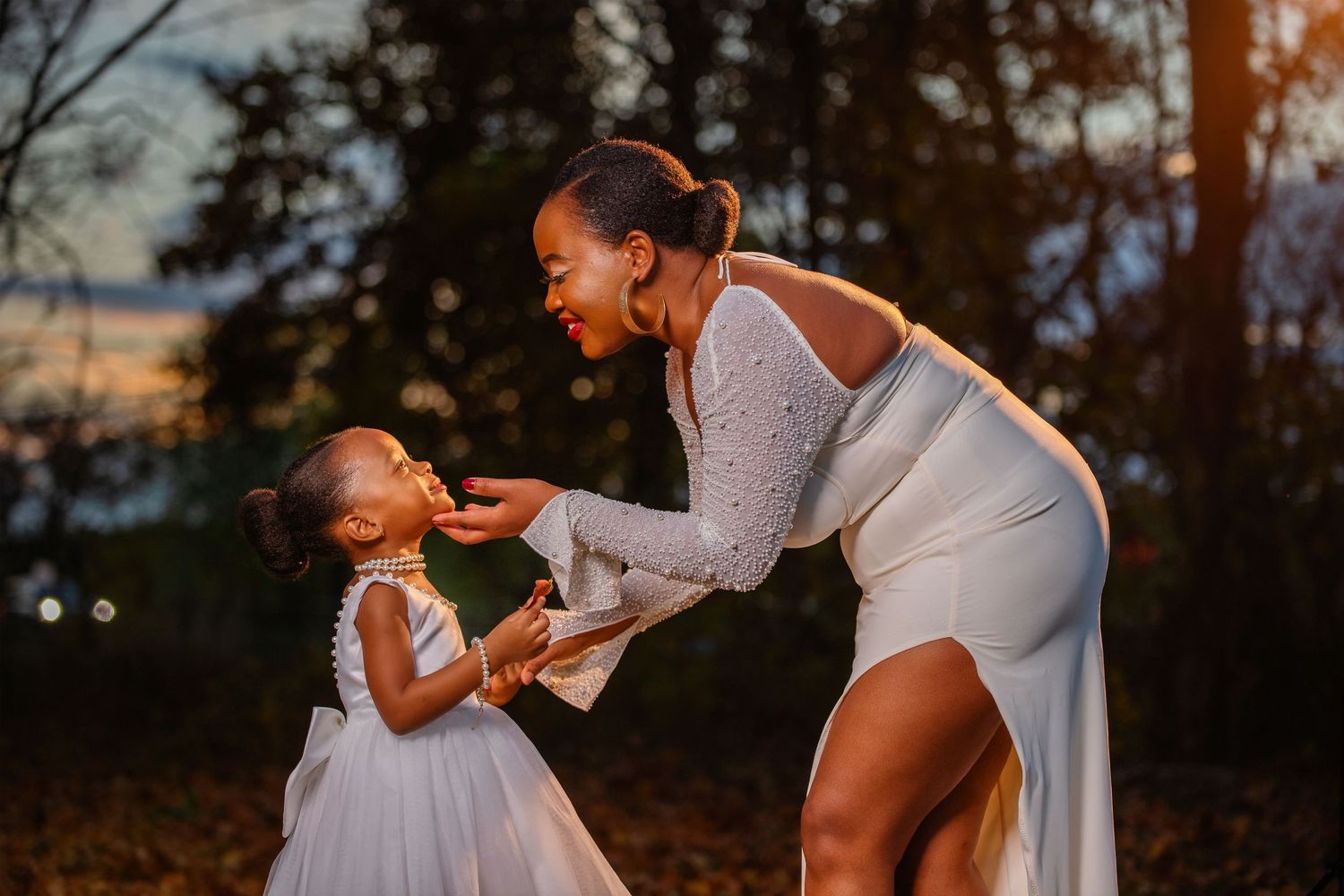 Outdoor photoshoot featuring elegant white dresses against a sunset backdrop.