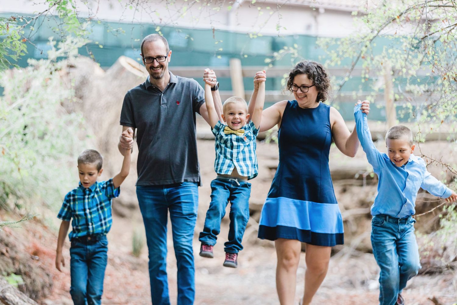 A family of five walks together, with three children wearing matching blue outfits.