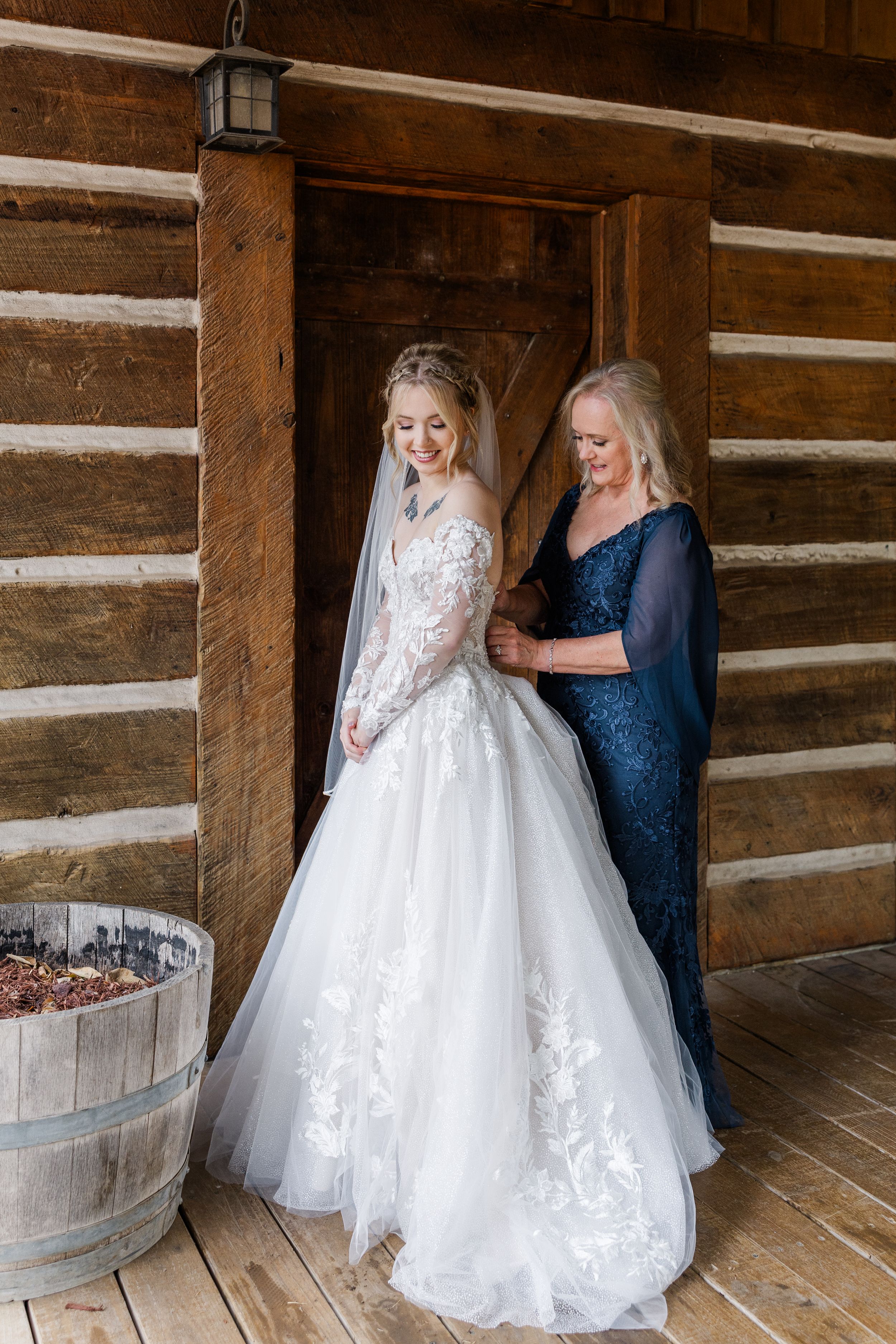 mom helping bride into dress