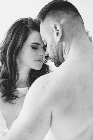 Intimate black and white portrait of couple in close embrace.