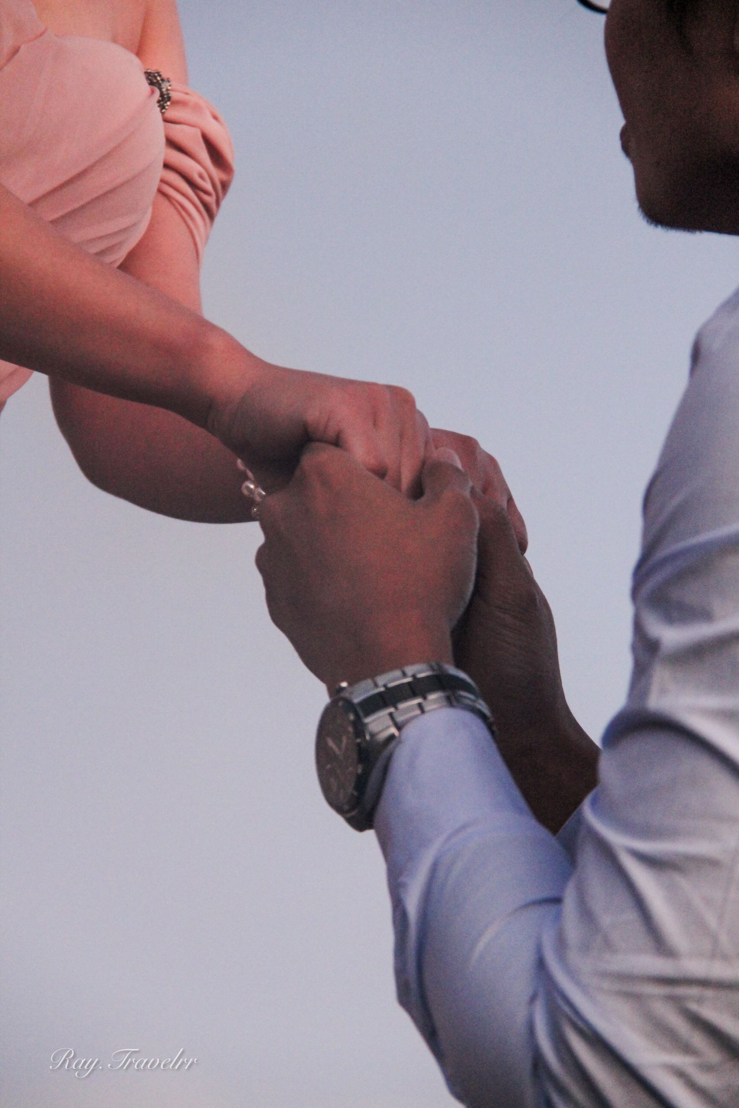 Close-up of hands during proposal moment with wristwatch visible.