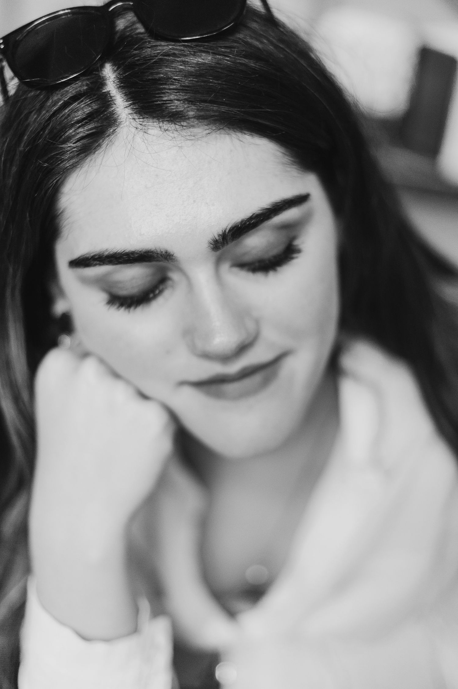 Close-up black and white portrait showing soft makeup application and closed eyes.
