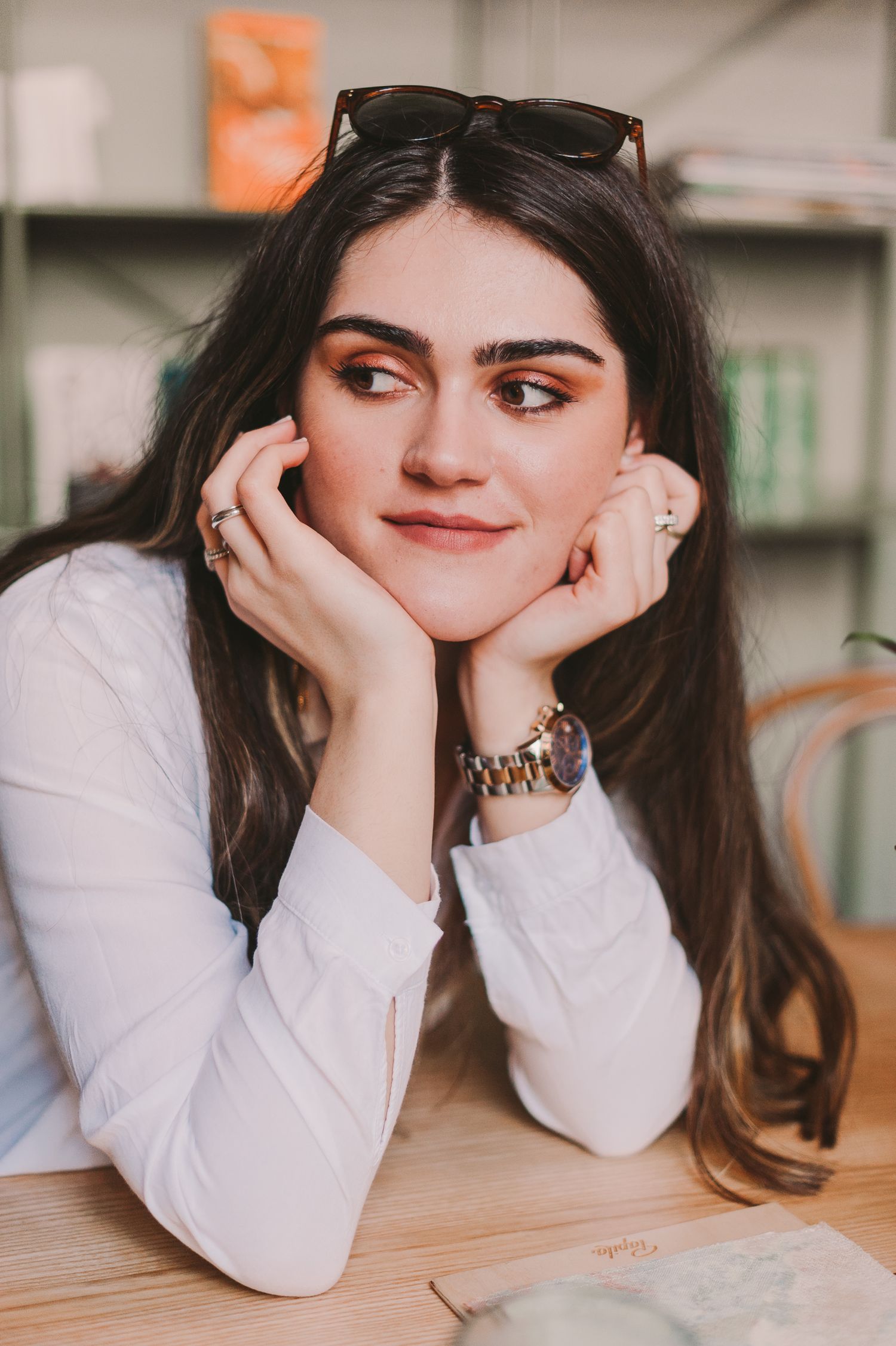 Series of casual portraits showing playful expressions while resting on hands at a table.