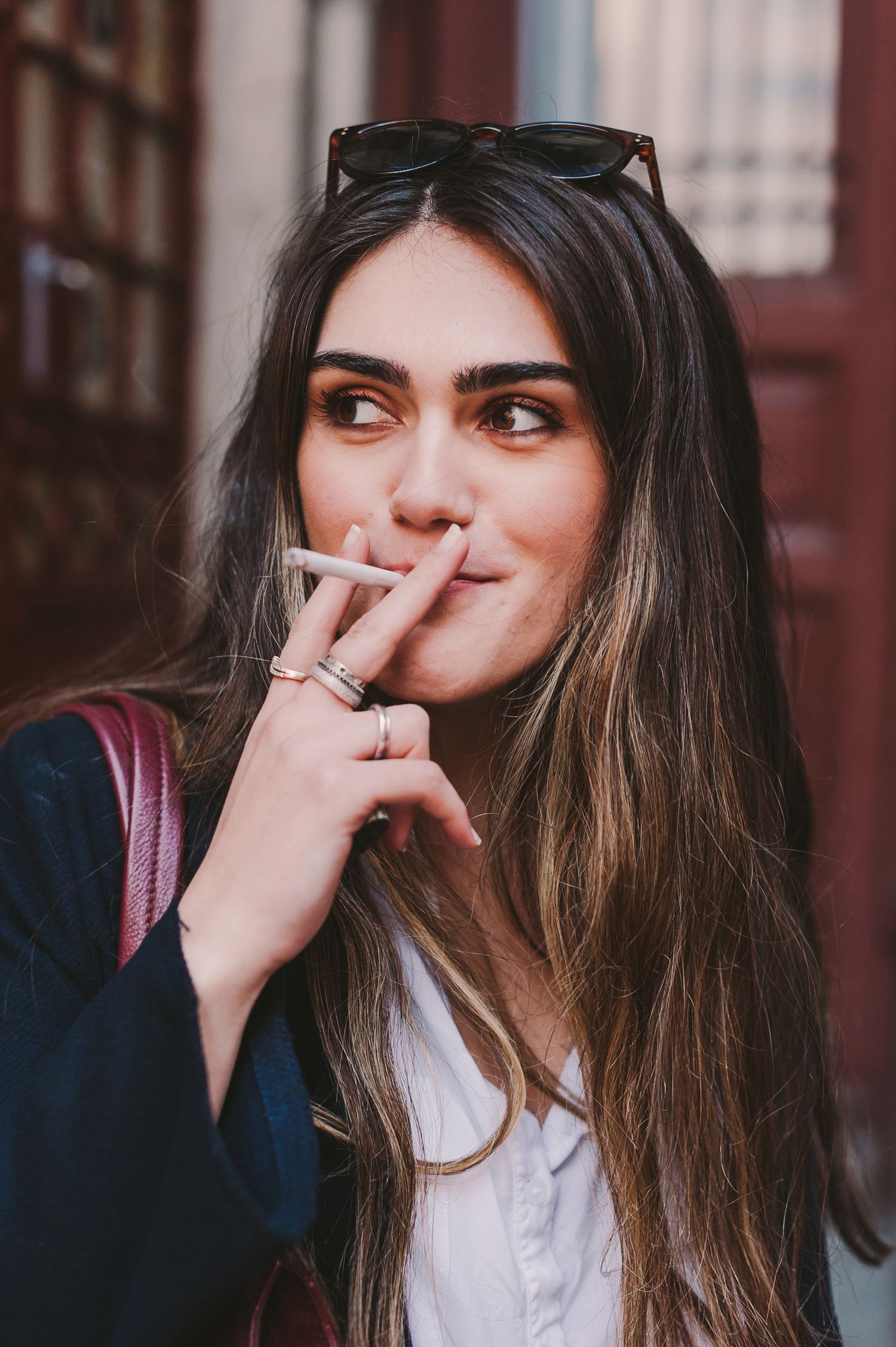 Collection of candid portraits showing various poses and expressions against a brick wall background.