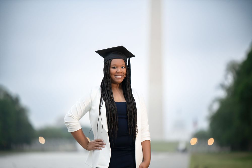 Graduation photo session near the Washington Monument with graduate in professional attire.