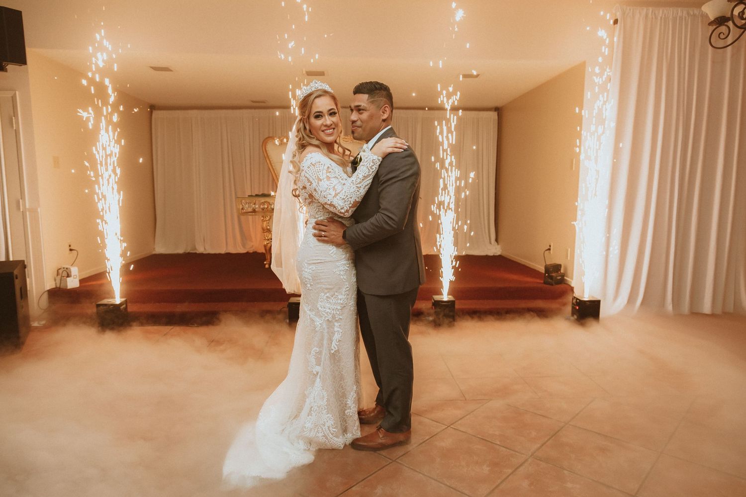 Romantic wedding portrait with sparkler fountains and fog effects creating dreamy atmosphere.