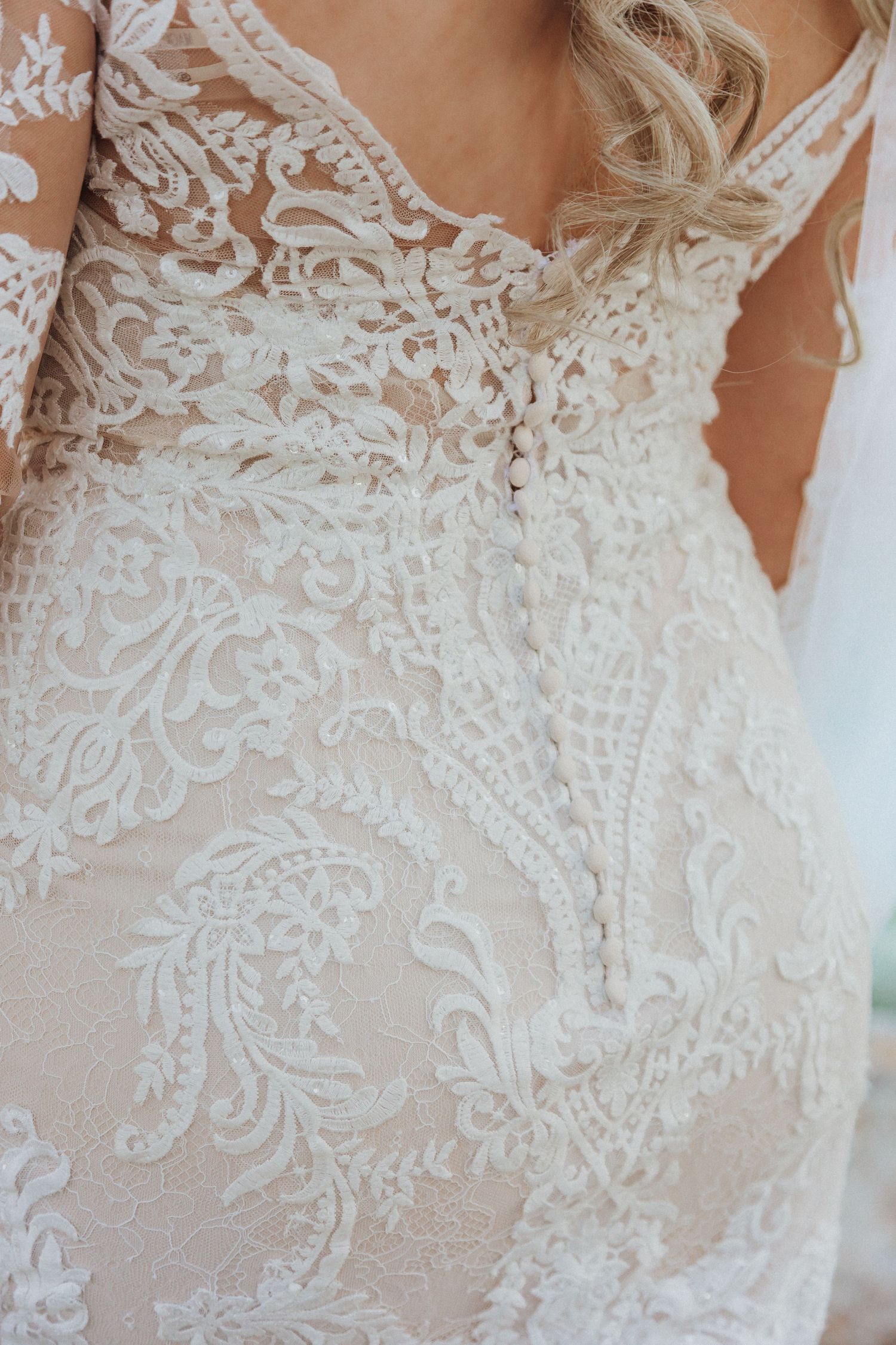 Close-up detail of intricate lace pattern on wedding dress bodice.