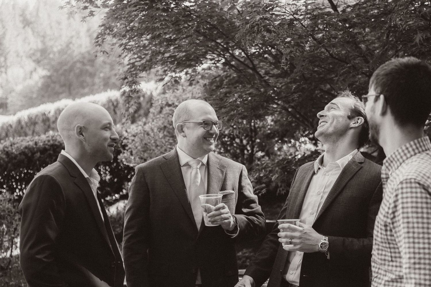 Small group of guests engaged in conversation during an outdoor garden party.