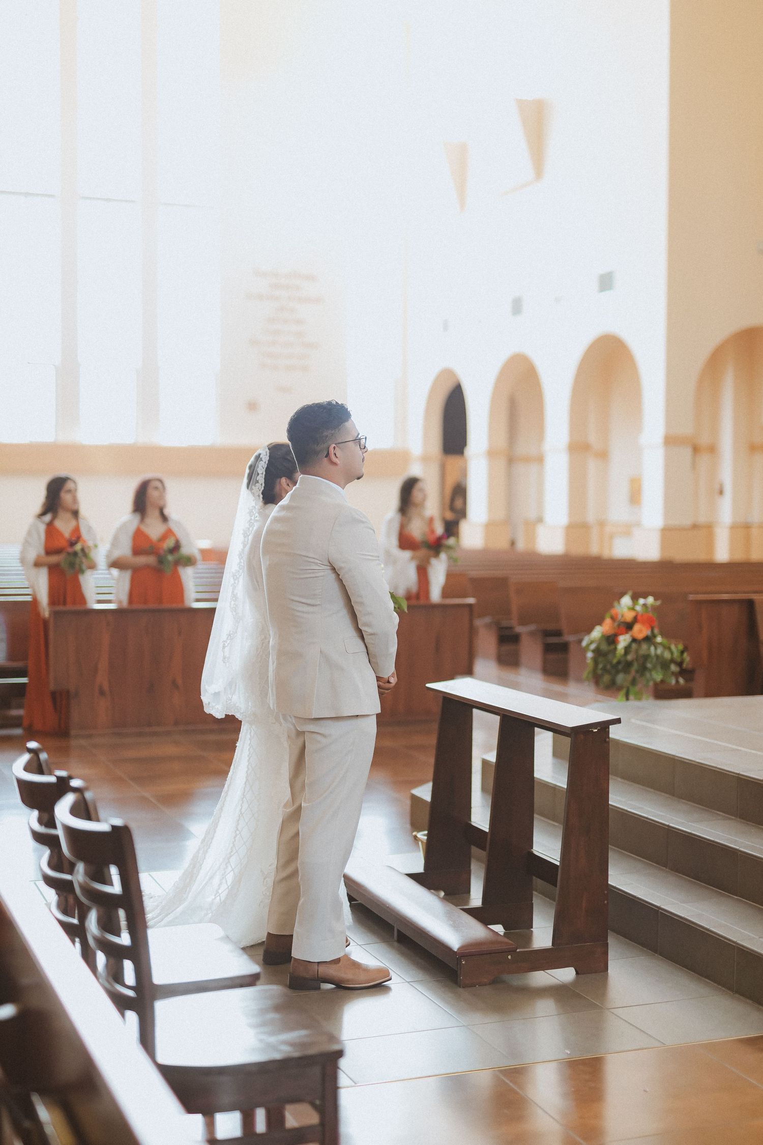 Wedding ceremony in progress inside traditional church with terra cotta floors.