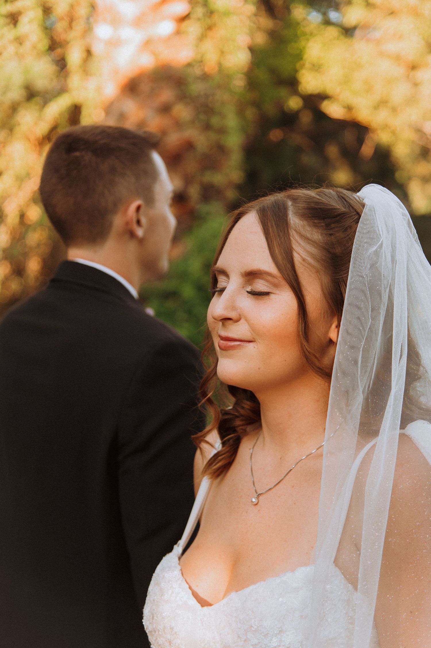 Serene bridal portrait in golden sunset light with veil detail.