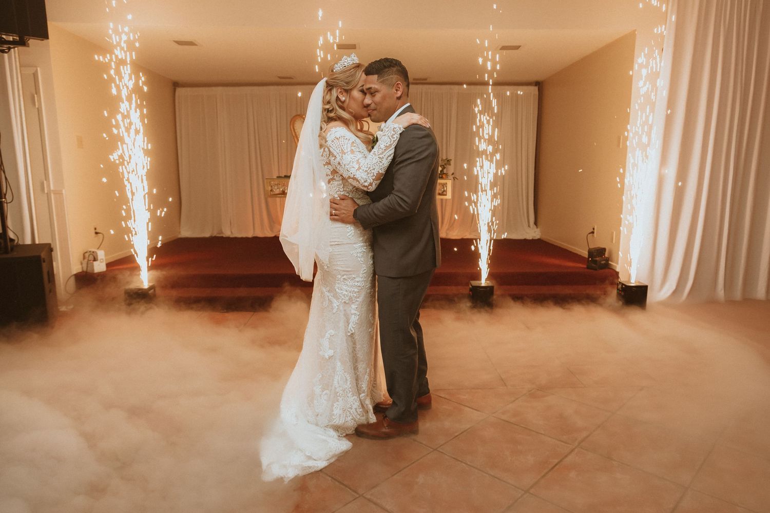 Couple embraces during wedding dance with dramatic lighting and special effects creating ambiance.