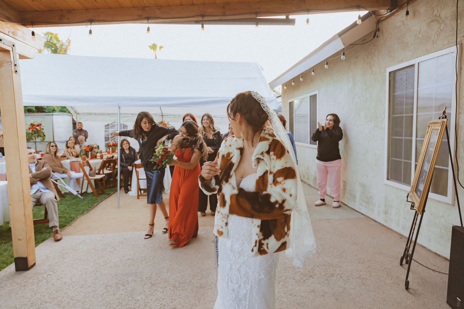 Wedding guests gather to catch the bouquet during the traditional toss ceremony.