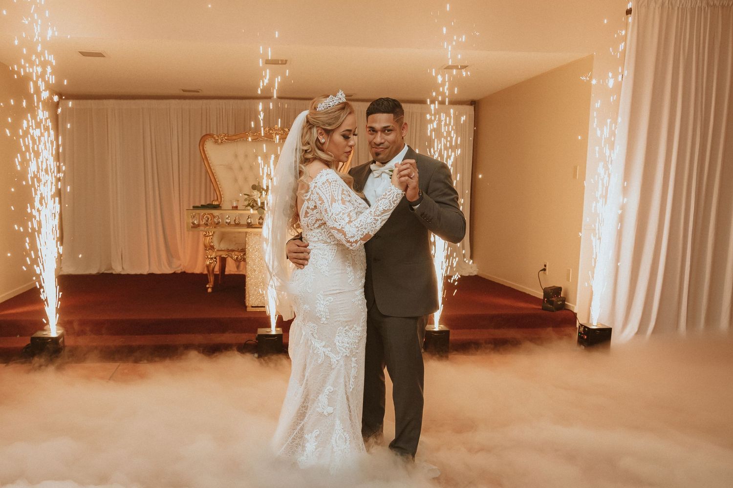 Newlyweds dance together as sparklers create a magical atmosphere on the dance floor.