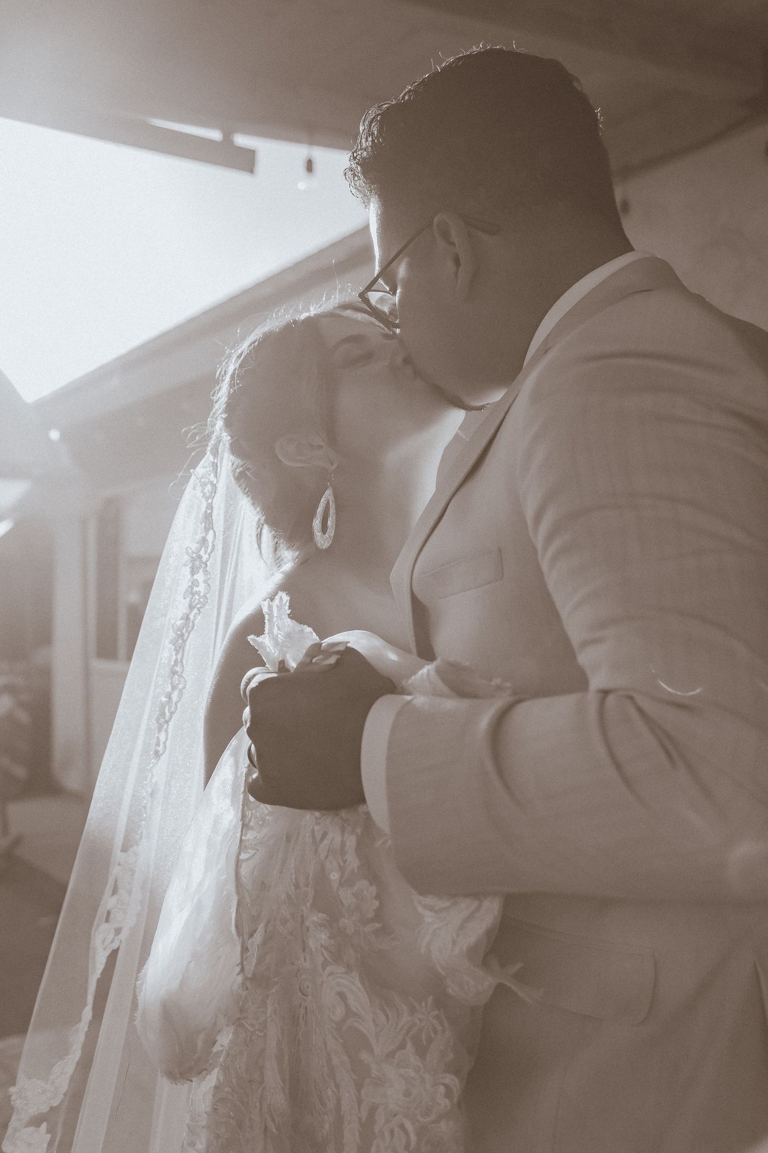 Artistic black and white close-up of newlyweds sharing tender moment during wedding dance.