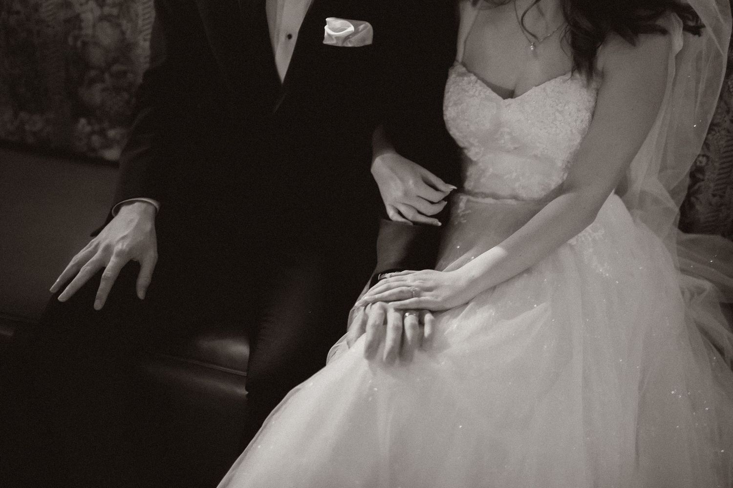 Black and white wedding photo showing couple seated close together in formal attire.