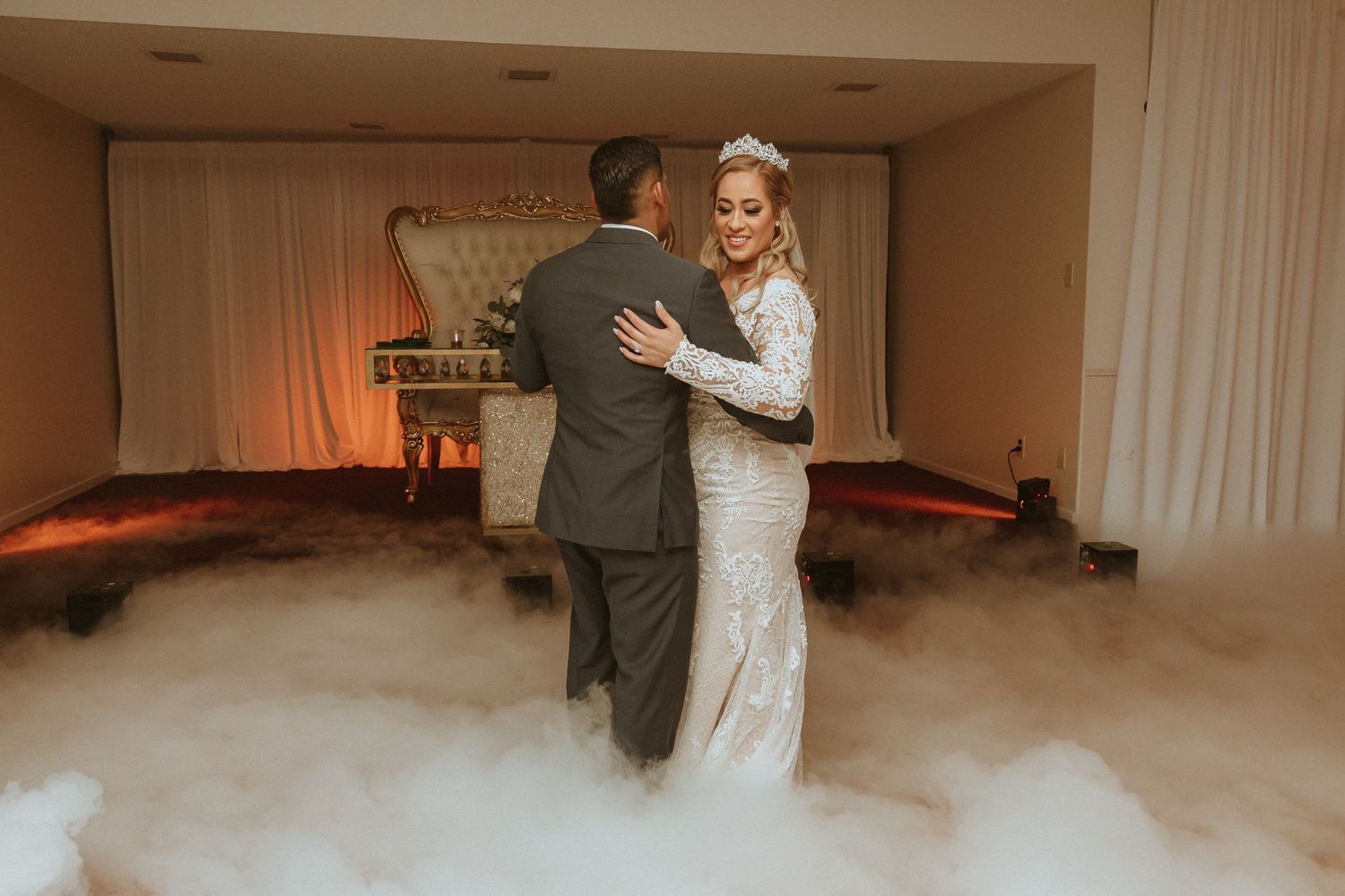 Intimate dance moment captured in elegant venue with dreamy fog effects.