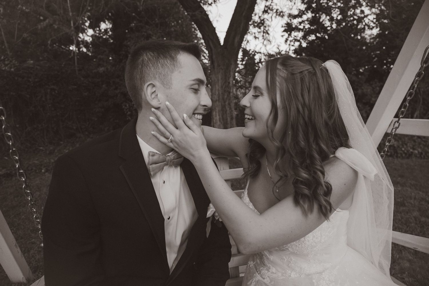 Black and white romantic portrait of newlyweds sharing affectionate moment.