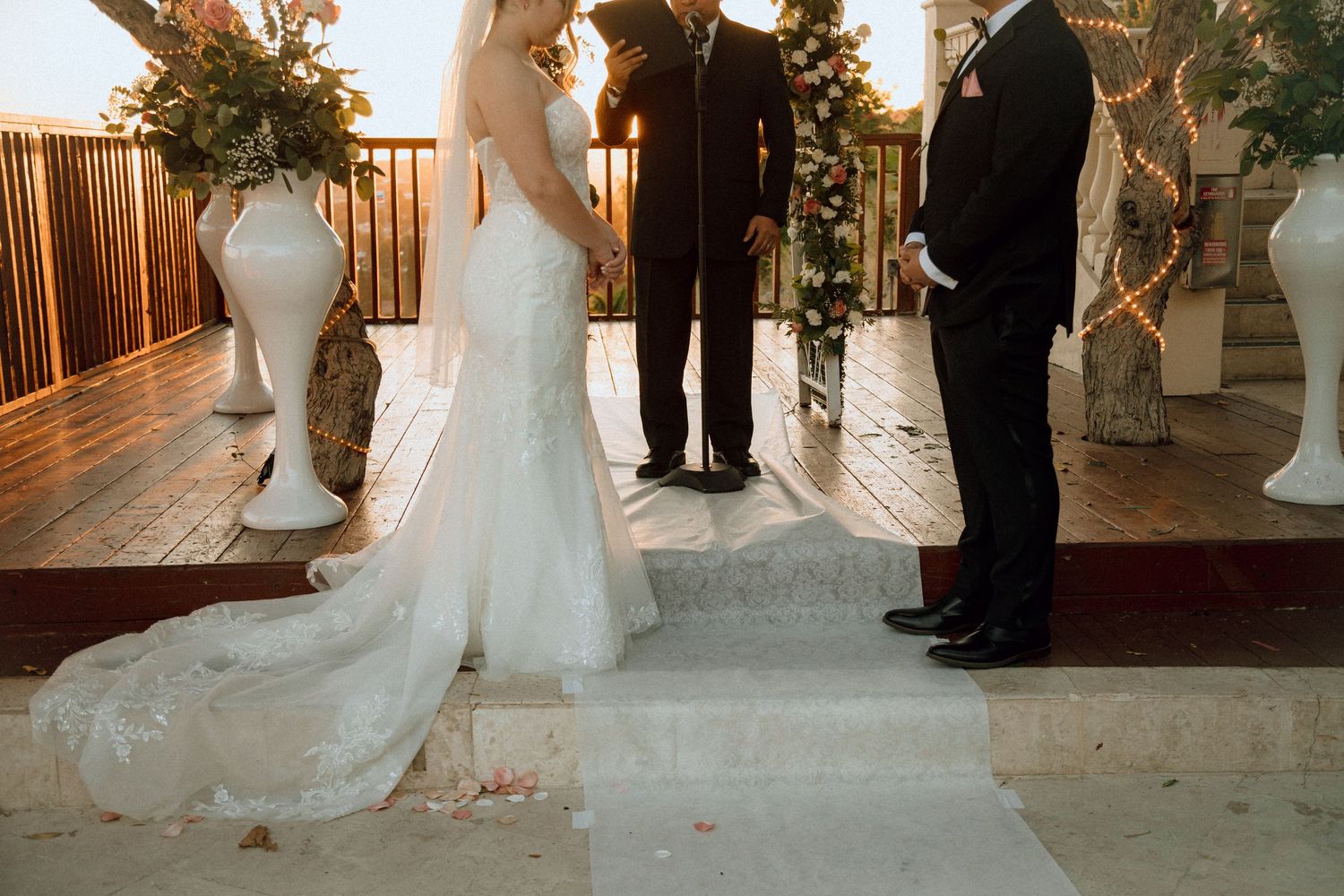 Outdoor wedding ceremony space with white flower arrangements and wooden details.