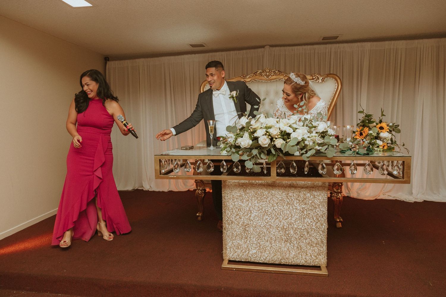 Wedding party dancing and celebrating behind elegantly decorated reception table.
