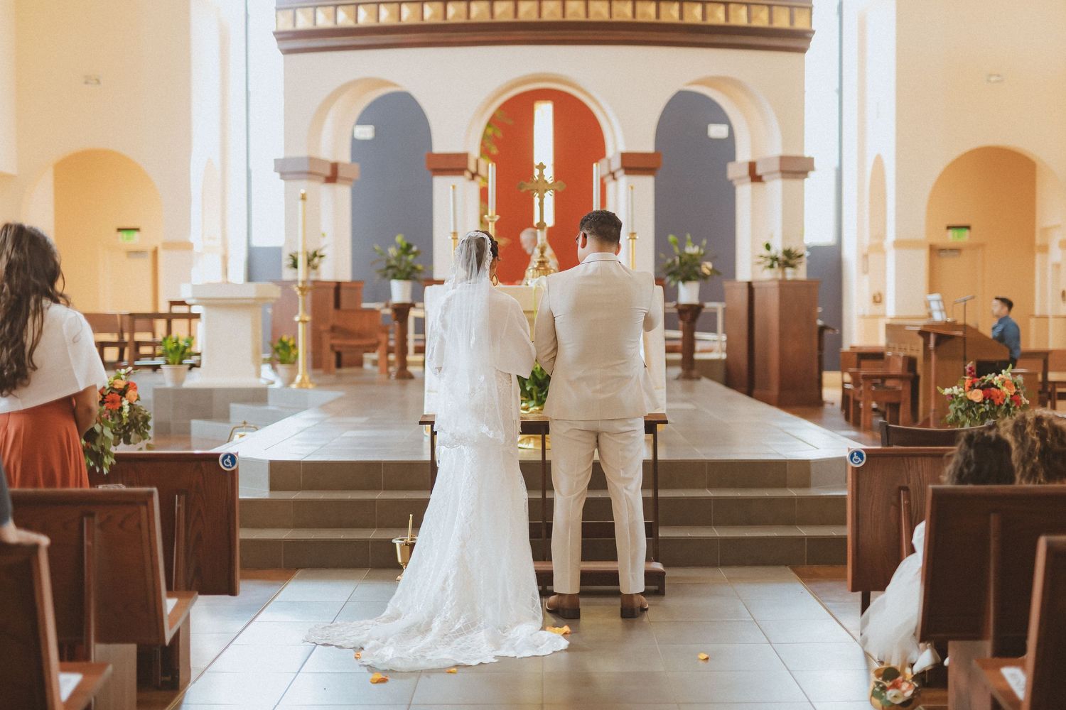 Couple stands at altar in church during wedding ceremony.