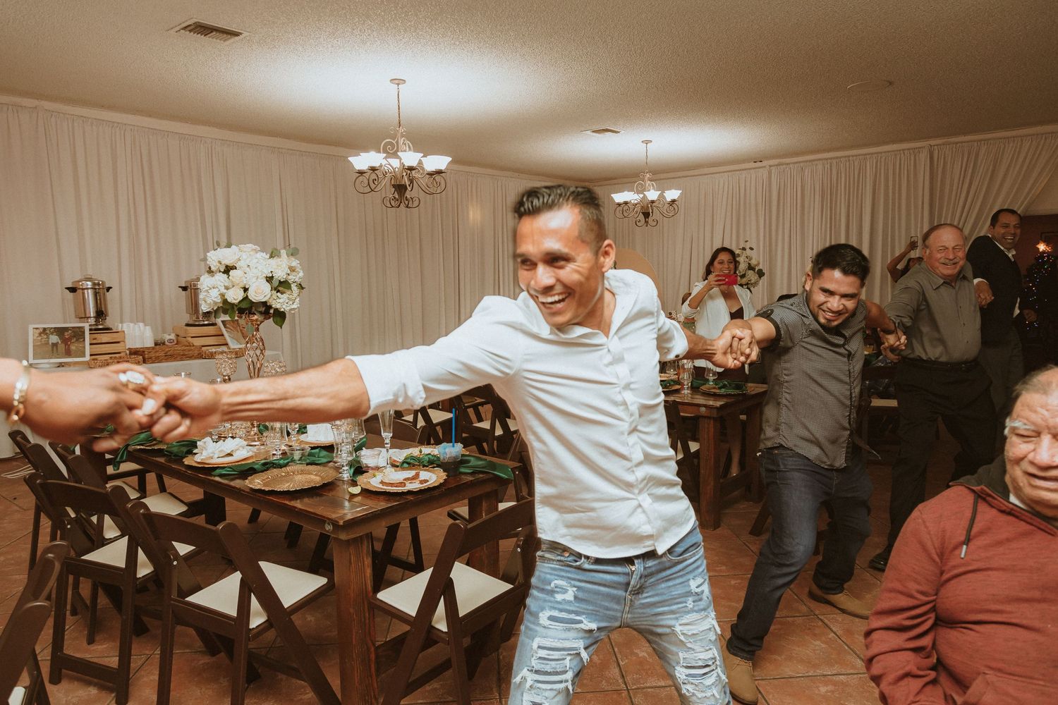 Party guests form a conga line during a lively wedding reception.