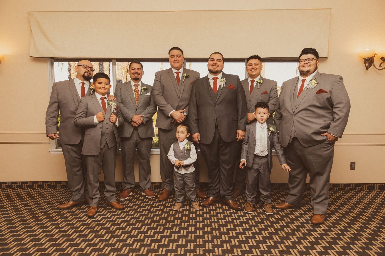 Wedding party group photo of groomsmen in gray suits with young ring bearers in formal attire.