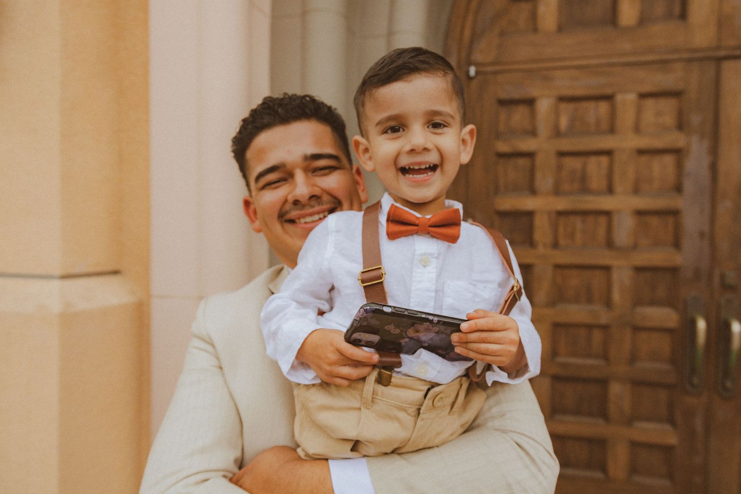 A warm embrace and shared smile between two people against a wooden door background.