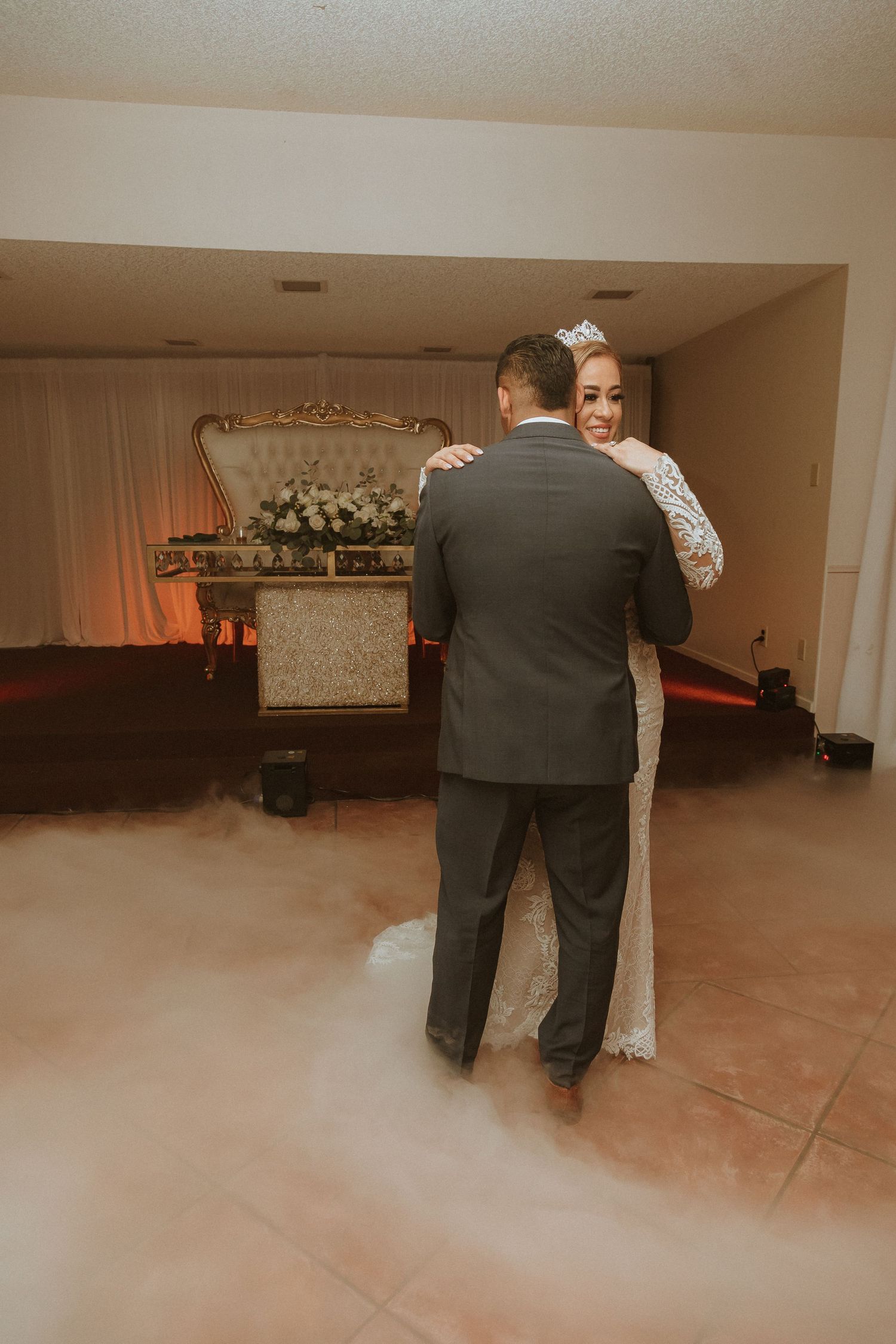 A romantic wedding dance captured from behind with fog effects and floral decorations.